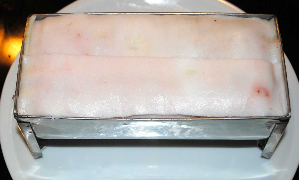 Fleischmasse mit der Entenbrust in der mit Speck ausgelegten Form, bereit für den Ofen